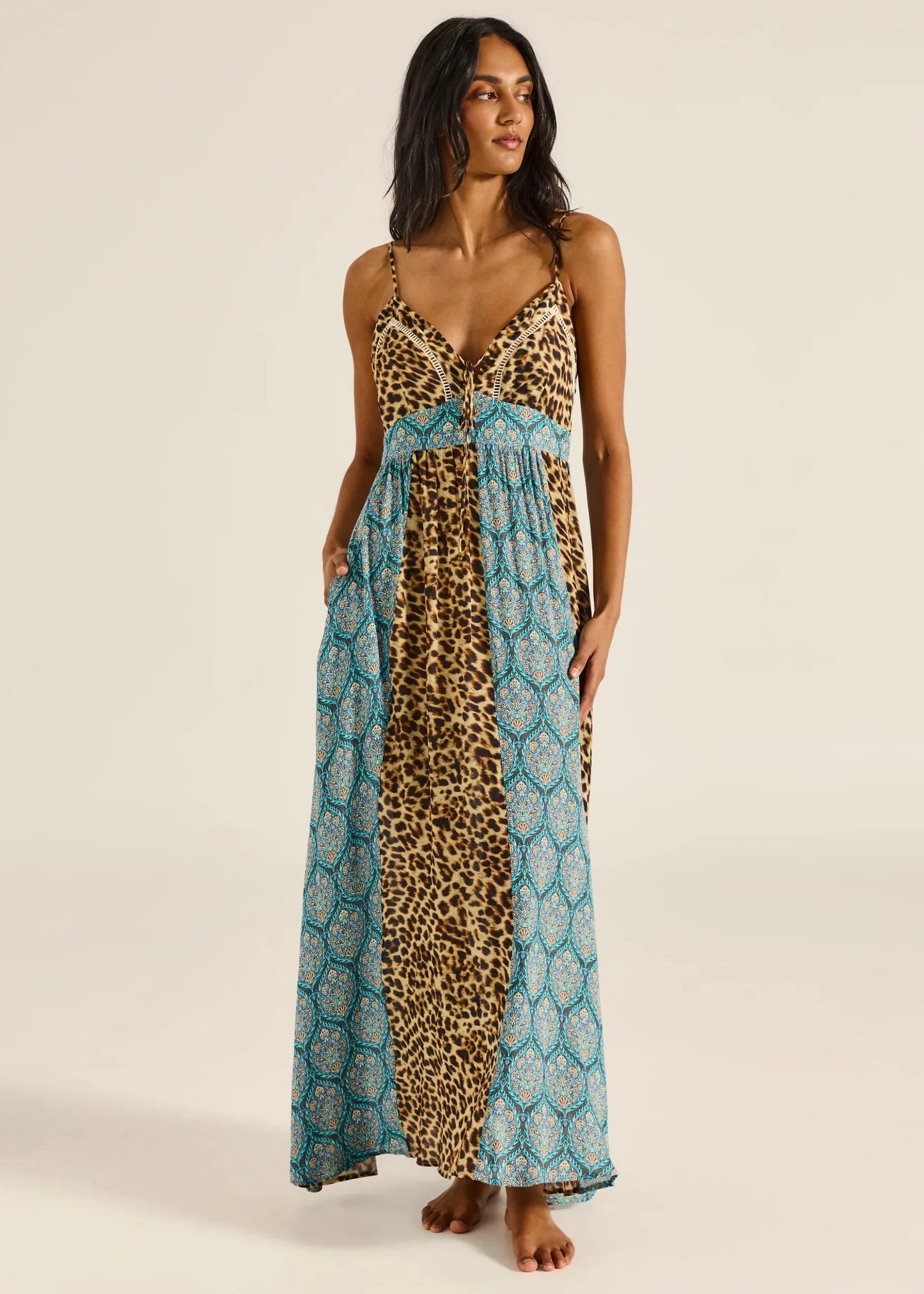 Woman wearing a leopard print and blue patterned dress on a beige background